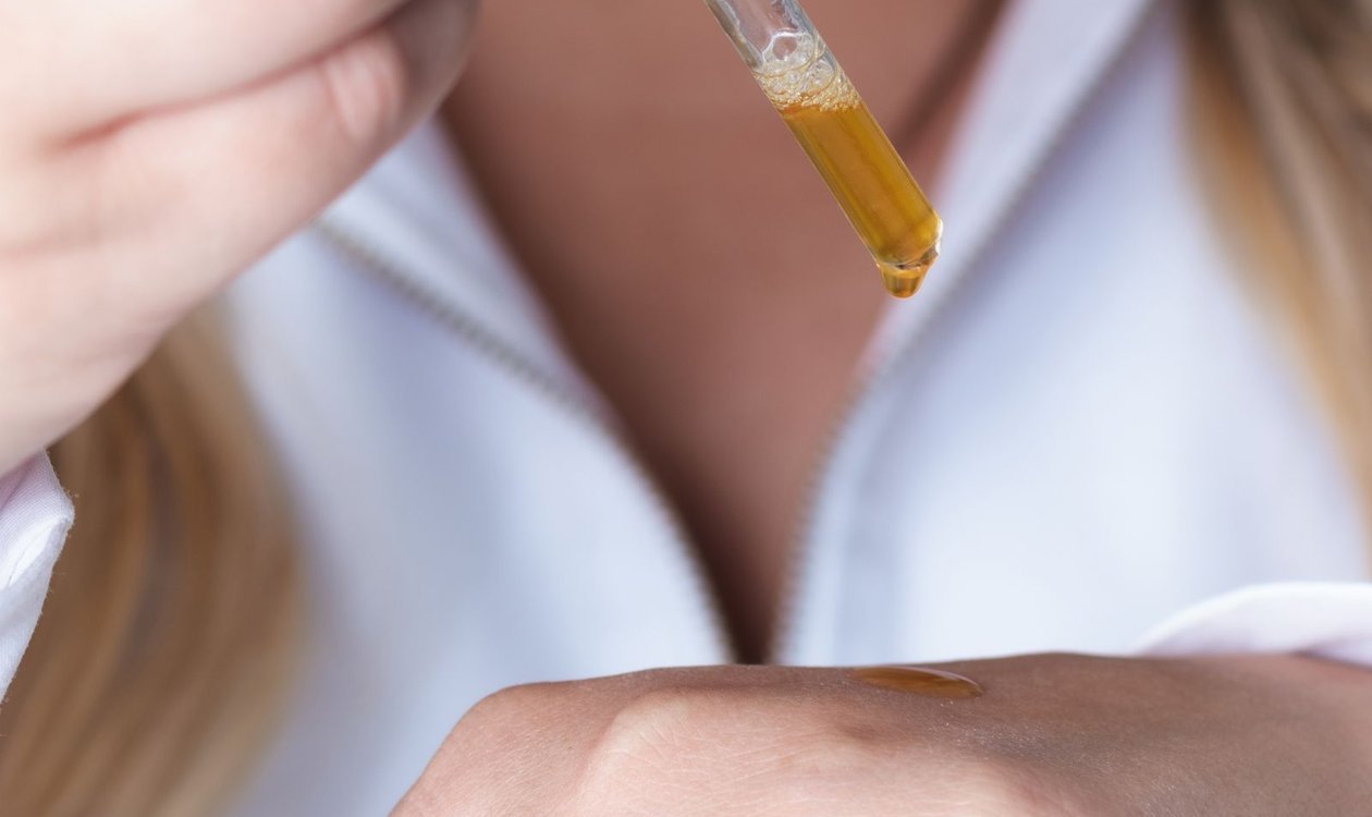 Woman applying vitamin C serum to her face with a dropper