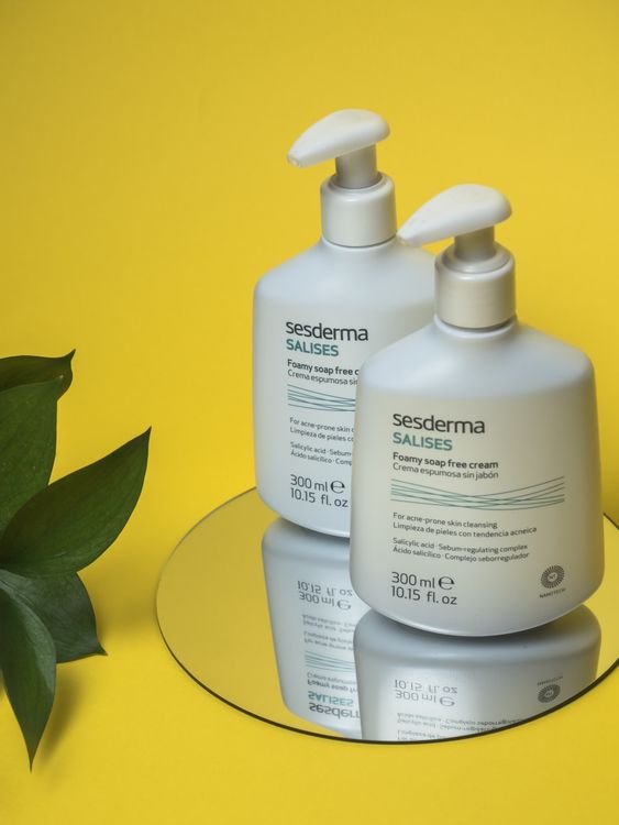 Skincare cream bottles arranged on a mirror, showing a complete skincare routine