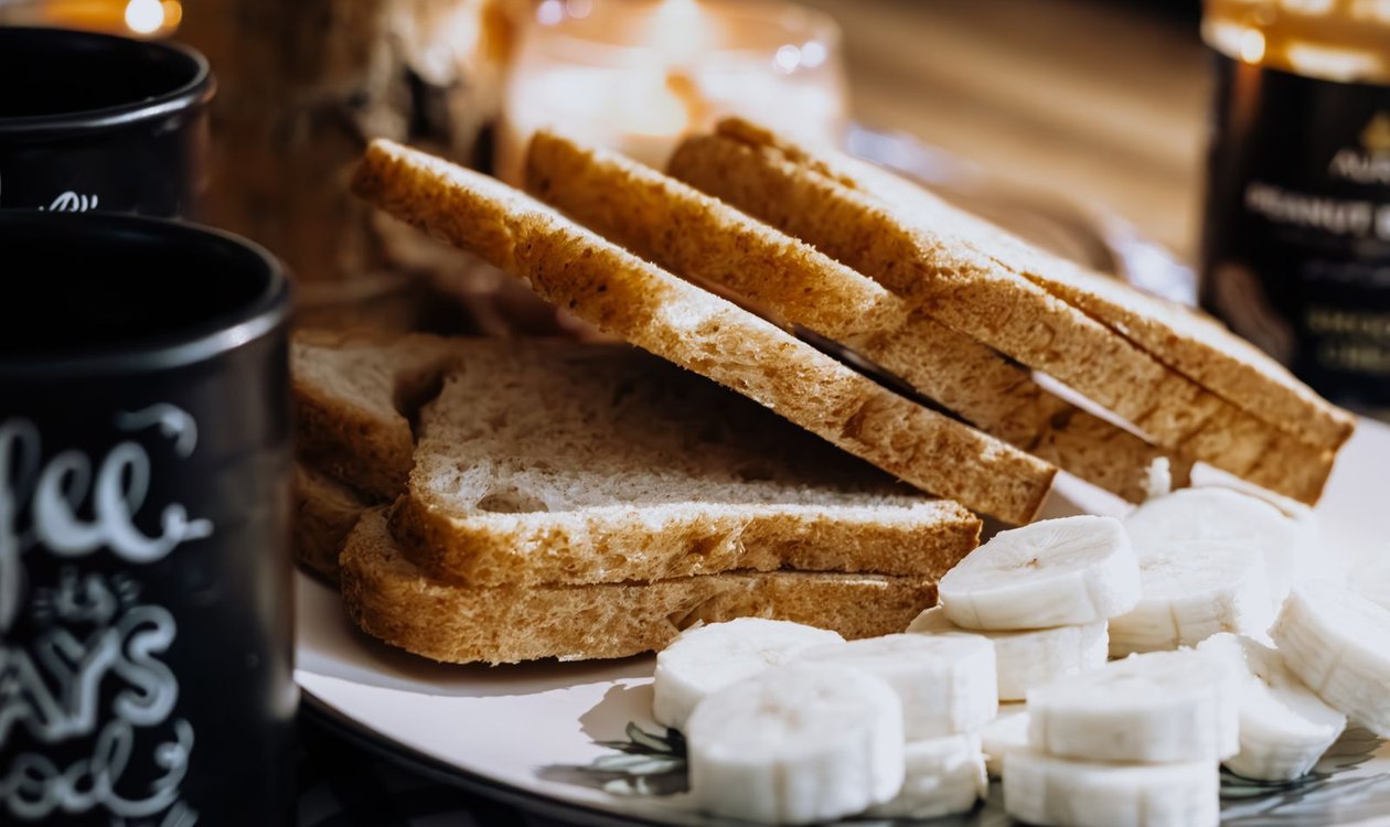 Sliced banana bread served with bananas and coffee for breakfast