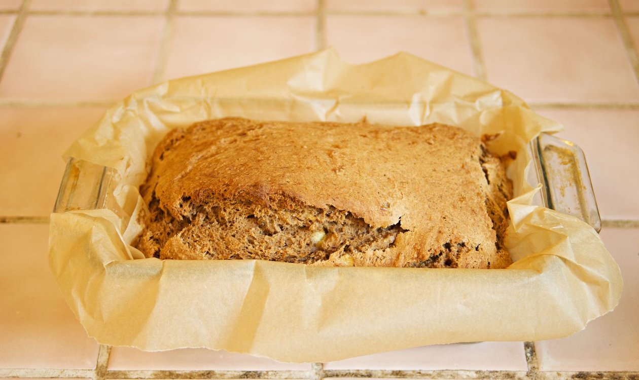 Golden banana bread loaf fresh out of the oven in its pan