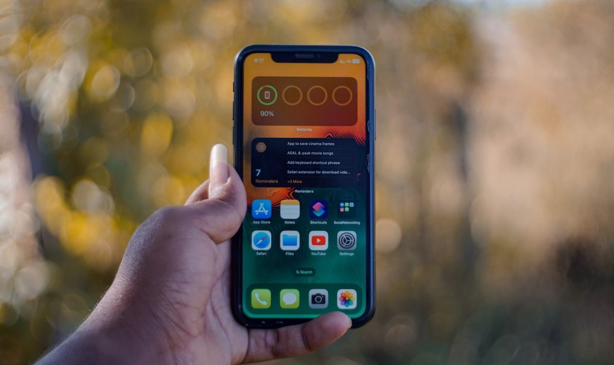 Person holding a smartphone to check battery settings
