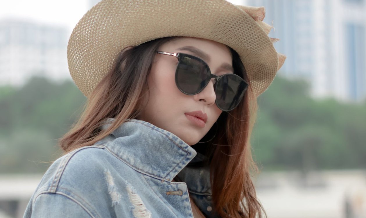 Woman in a denim jacket and sun hat on a summer day