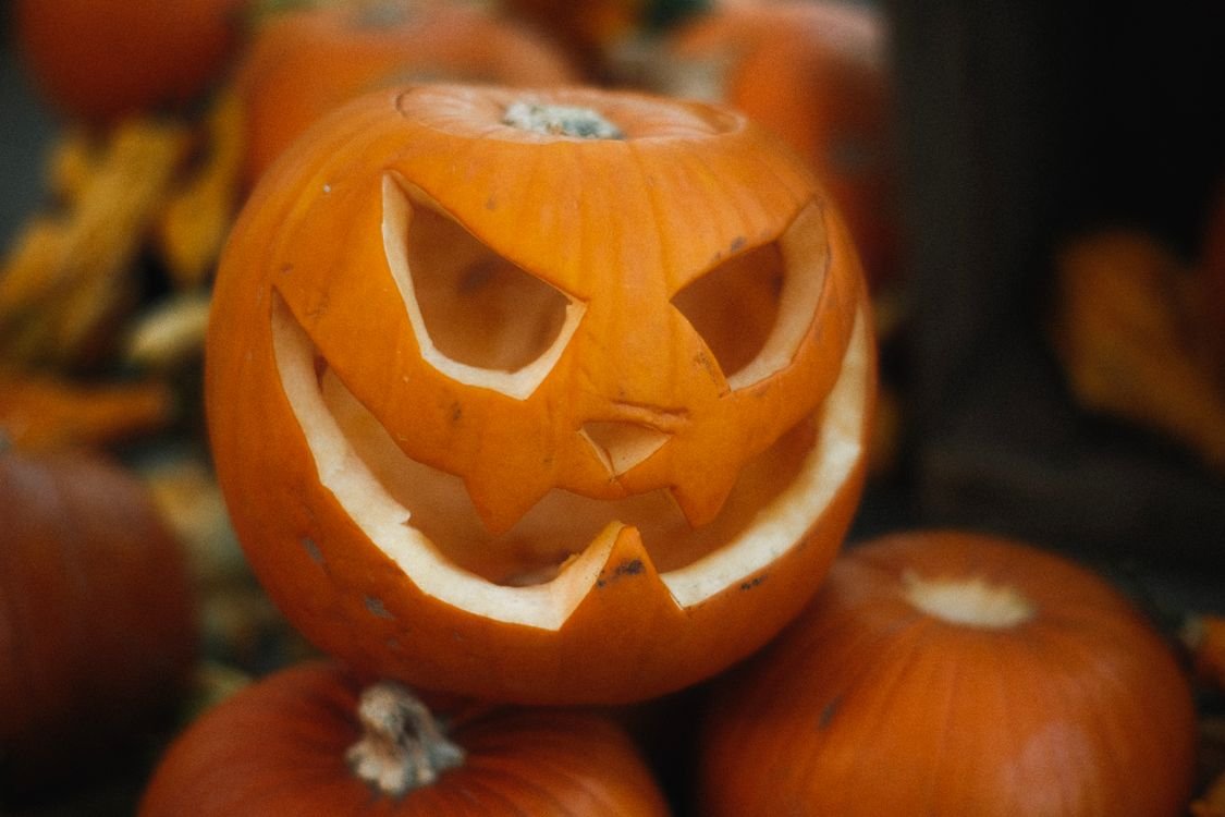 Carved jack-o-lantern surrounded by pumpkins, perfect Halloween movie night decor